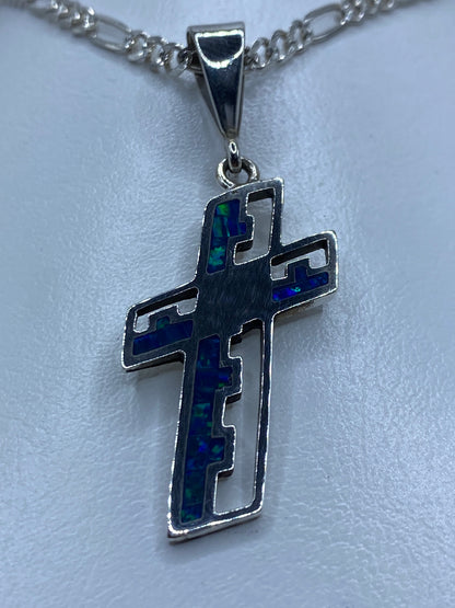 Detalle del ópalo azul incrustado en la cruz de plata, mostrando los tonos índigo y verde