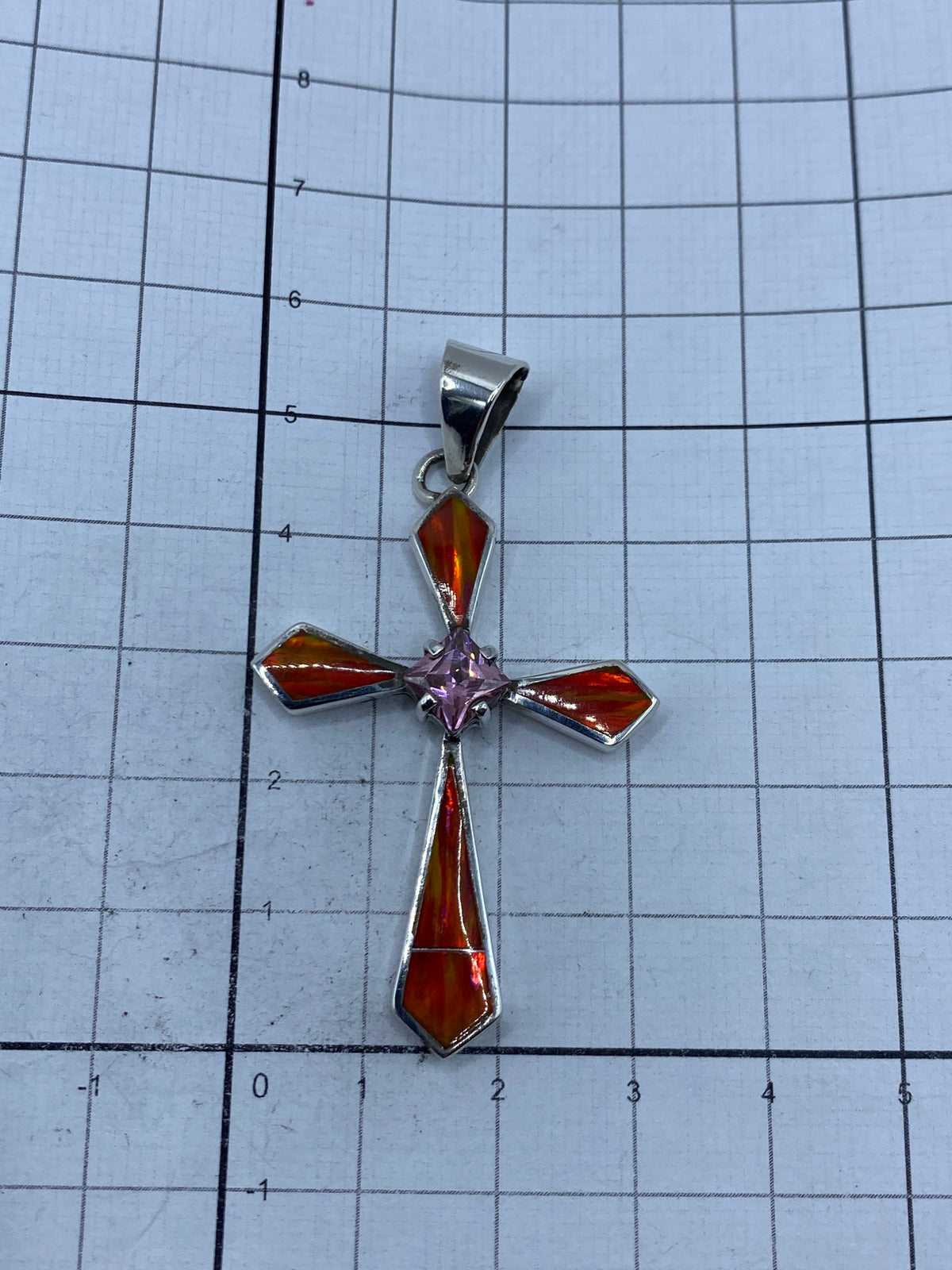 Cruz de plata 950 sobre fondo gris — visible el Quinto grabado en la base, peso 8.2 g en báscula