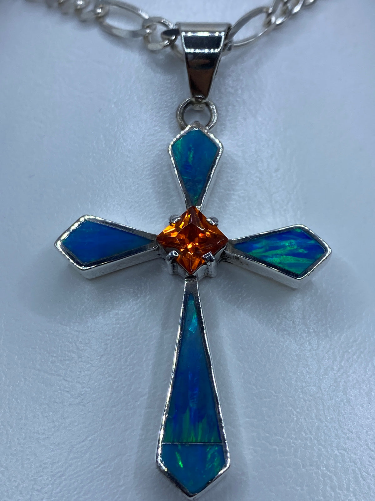 Cruz de plata con ópalo de fuego azul y circonia naranja en el pecho