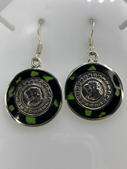 Detalle frontal de los glifos circulares del Calendario Azteca en los aretes de ónix