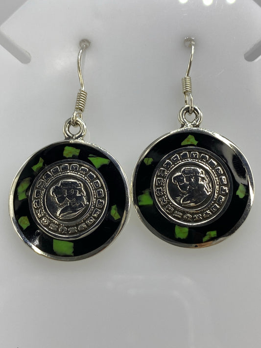 Detalle frontal de los glifos circulares del Calendario Azteca en los aretes de ónix