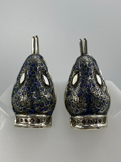 Detalle frontal de los aretes mostrando el lapislázuli azul intenso y la filigrana de plata