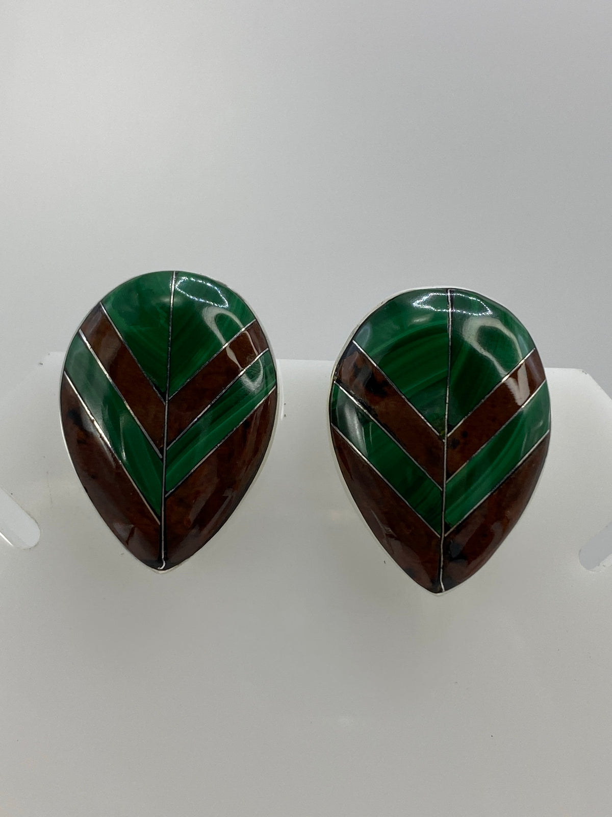 Vista frontal de los aretes mostrando la combinación de malaquita y ojo de tigre