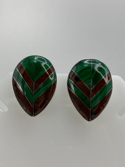 Vista frontal de los aretes mostrando la combinación de malaquita y ojo de tigre