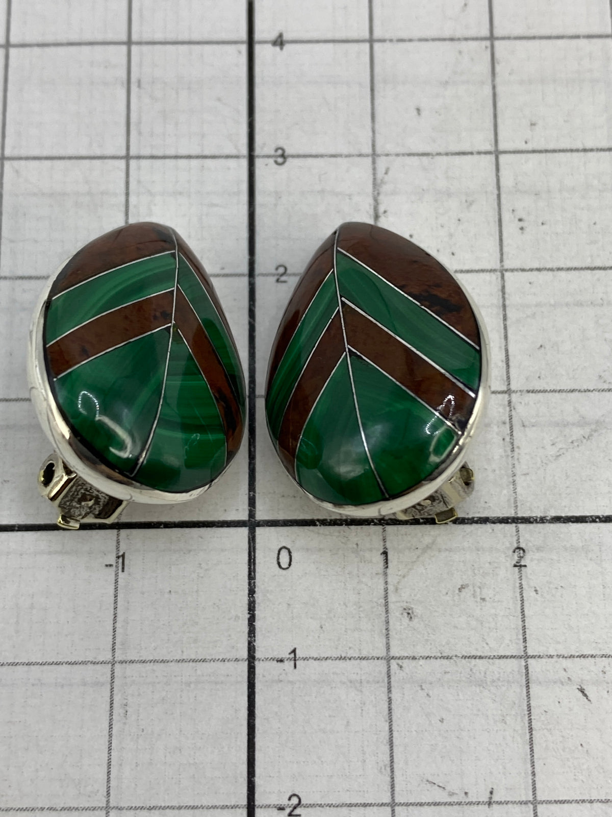 Aretes sobre fondo azul mostrando el Quinto 925 en la plata