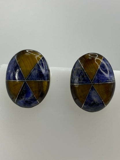 Detalle frontal de los aretes mostrando la combinación de piedras y el acabado pulido de la plata