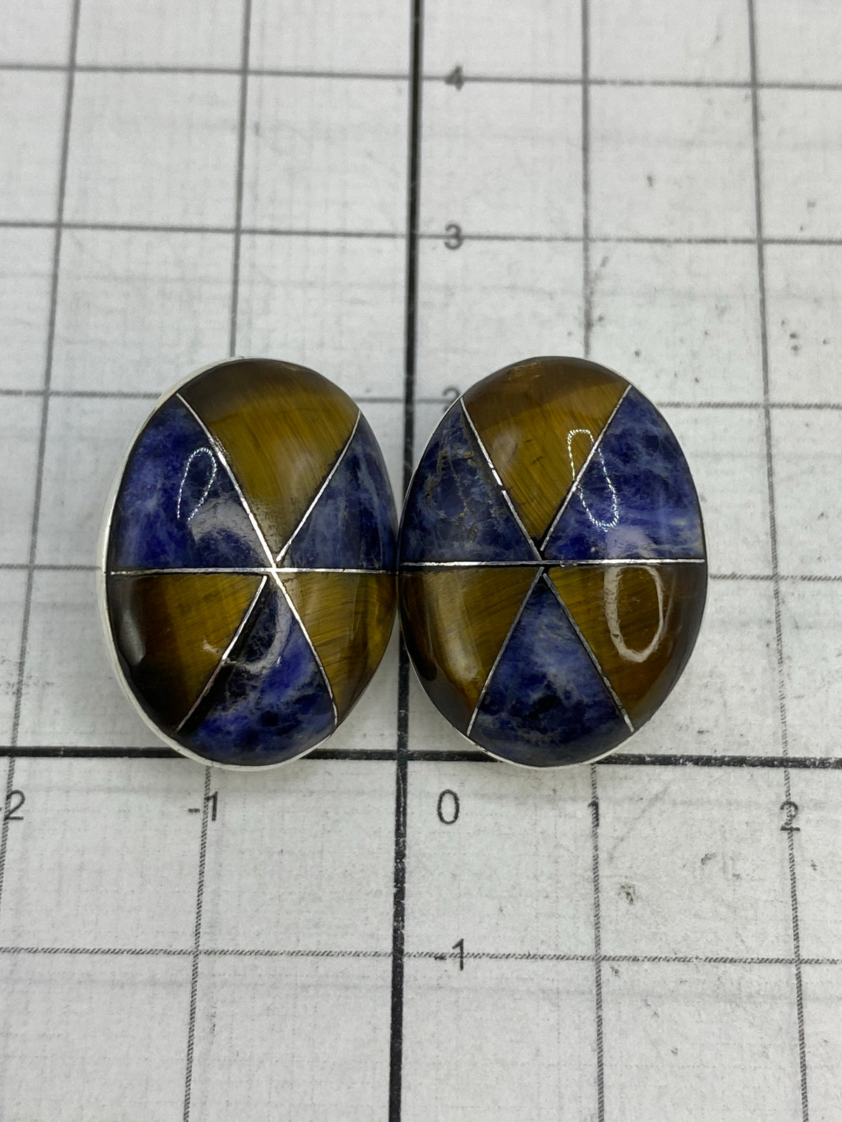 Aretes sobre regla mostrando el tamaño real de 2 cm de largo