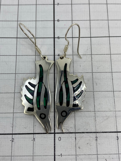 Aretes de plata sobre regla de centímetros mostrando el largo de 5.7 cm y ancho de 1.5 cm