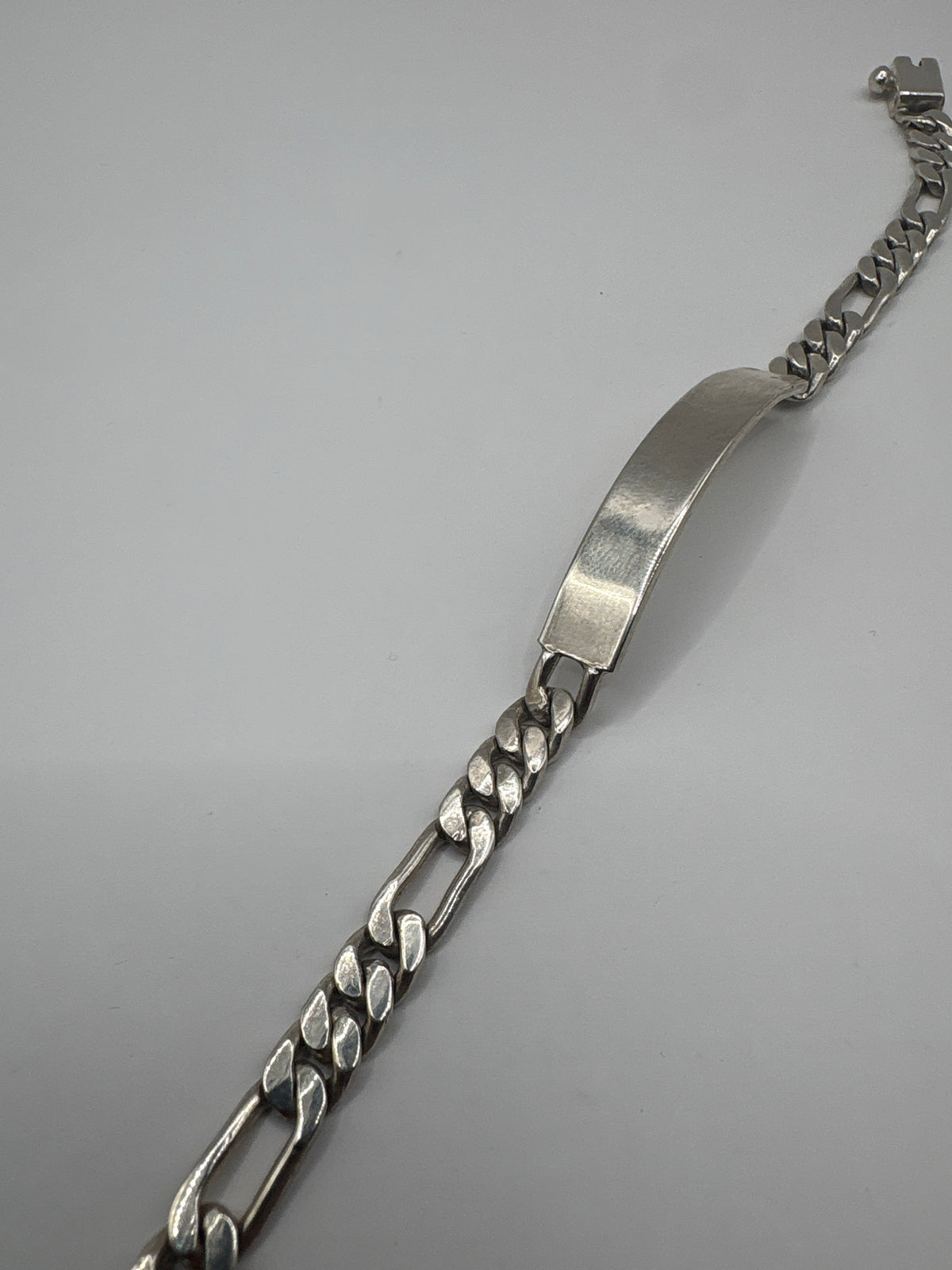 Pulsera de eslabones cubanos colocada en muñeca, acabado pulido brillante