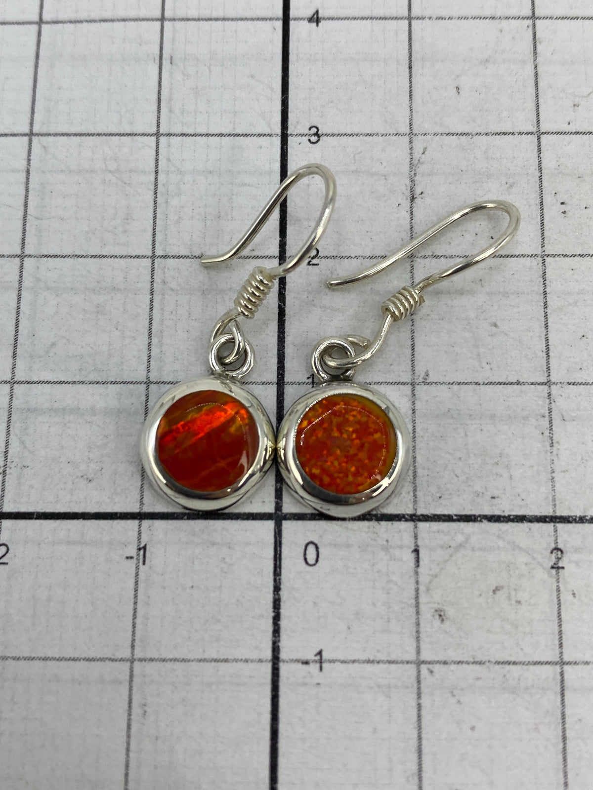 Aretes en la balanza digital mostrando peso total de 1.9 g, con certificado de lote