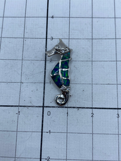 Caballito de mar de plata sobre regla métrica mostrando tamaño real de 3 cm