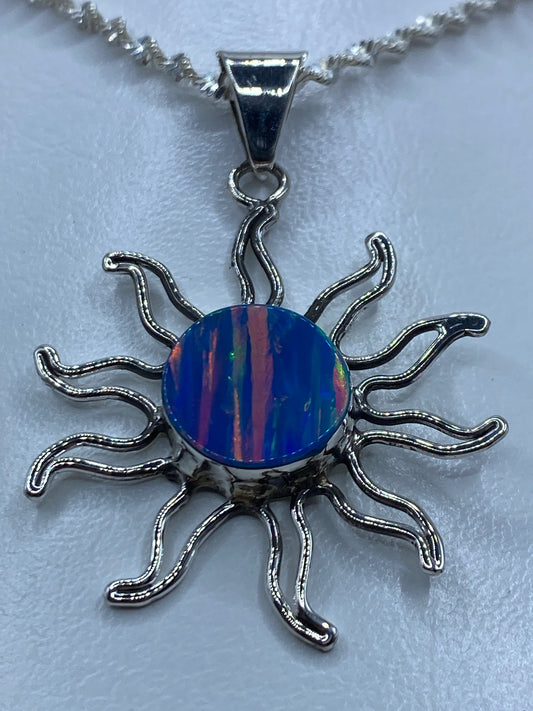 Detalle del ópalo de fuego azul dentro del dije solar de plata