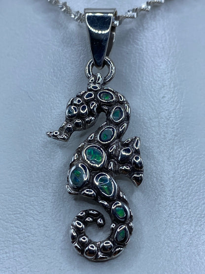 Dije caballito de mar en plata 950 con ópalo de fuego azul cielo sobre cadena de plata