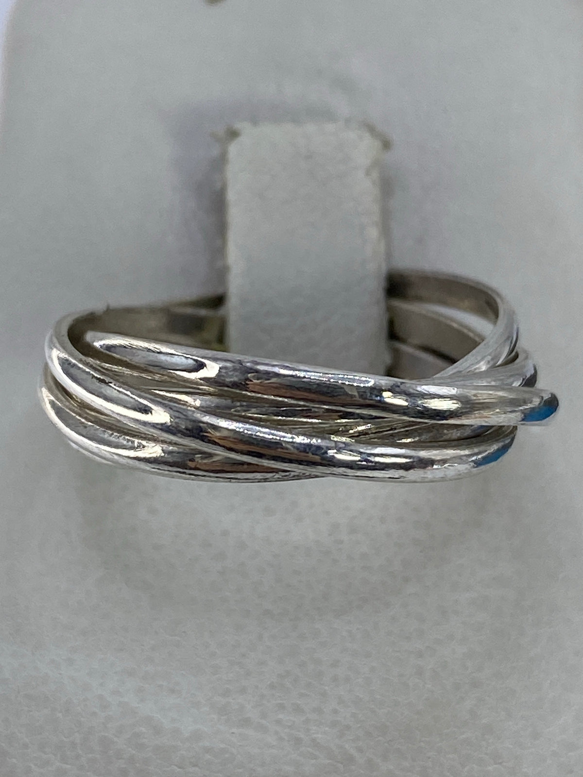 Anillo de plata con 5 bandas entrecruzadas en la mano