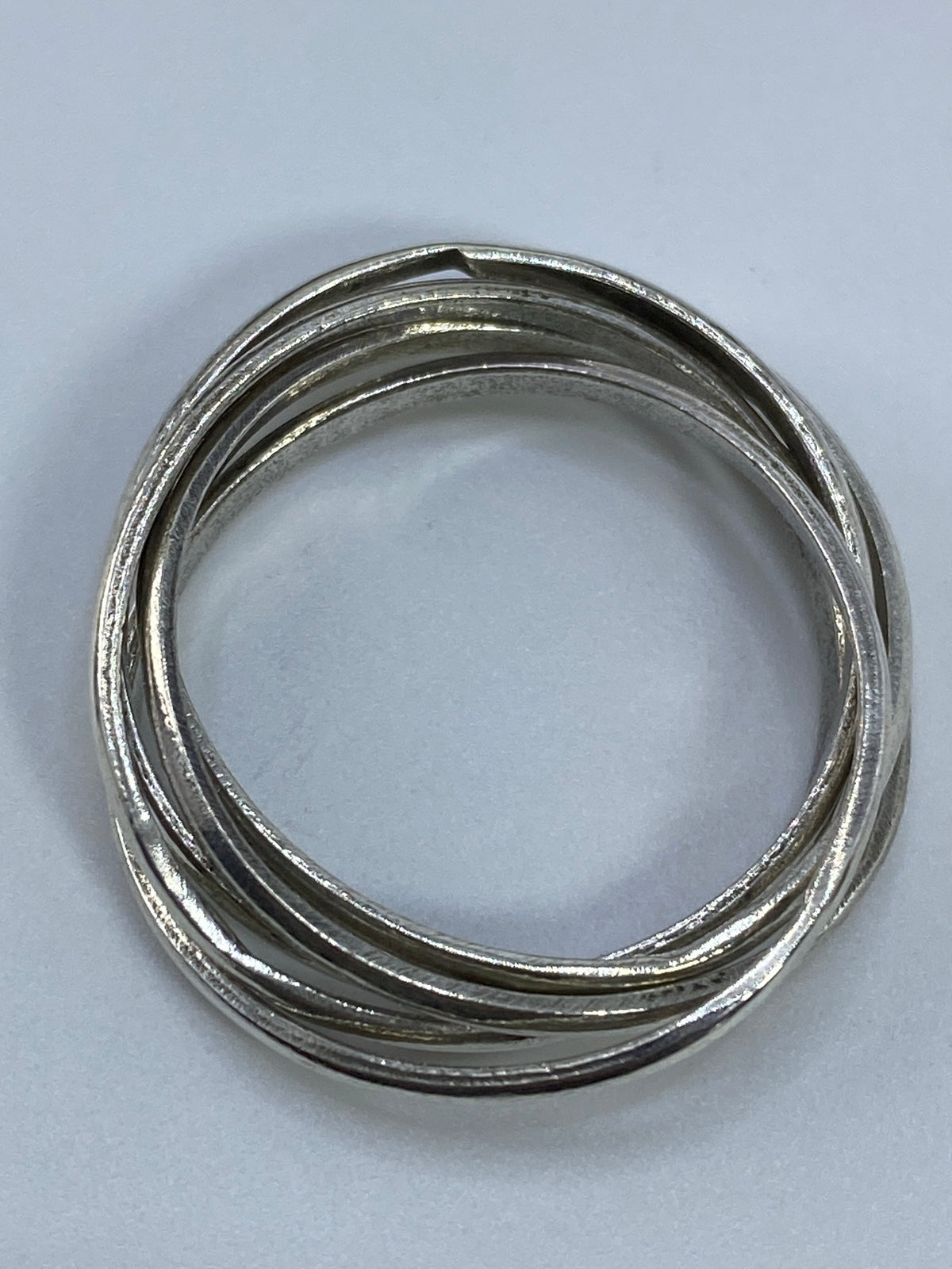 Vista frontal del anillo de bandas entrelazadas, sin piedras, acabado espejo