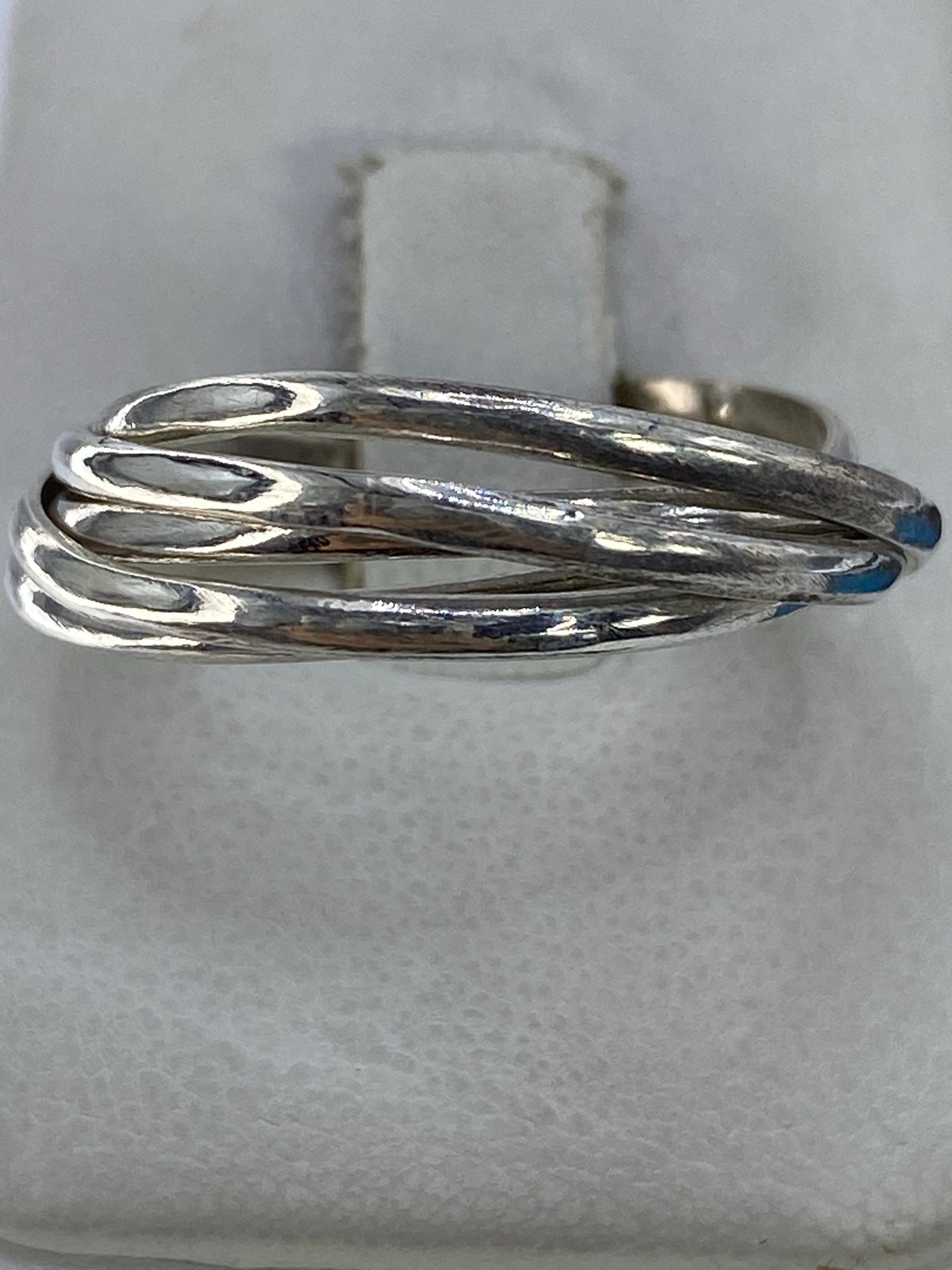 Anillo de plata con 5 bandas entrelazadas en la mano de una persona