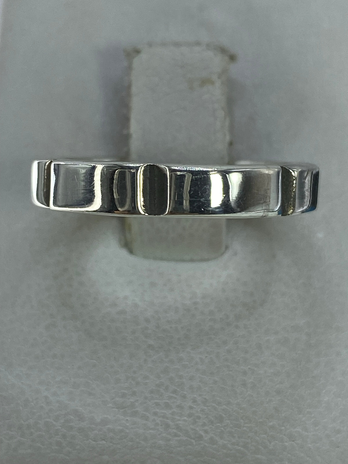 Anillo de plata 925 liso y minimalista en la mano de una mujer