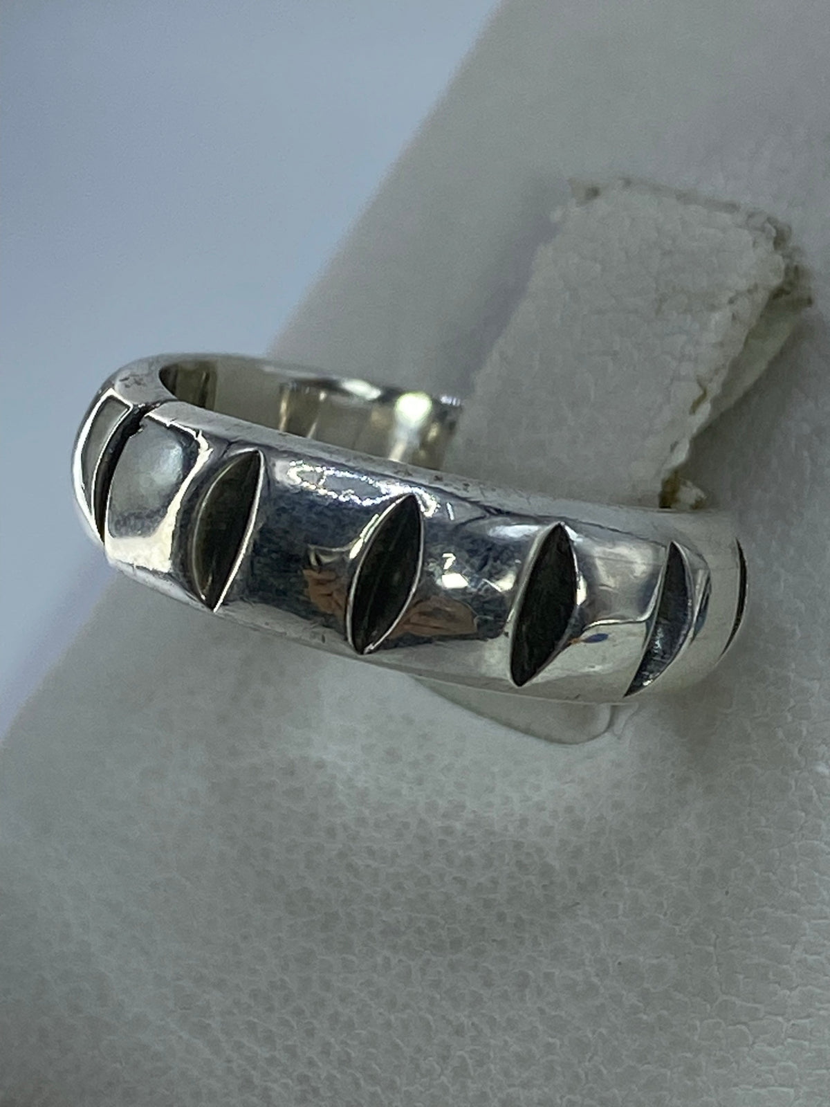 Anillo minimalista de plata en la mano, mostrando el pulido espejo