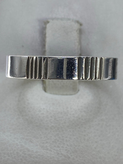 Anillo de plata 925 con líneas geométricas talladas, vista superior en estuche blanco