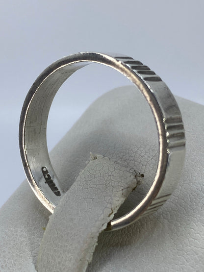 Anillo de plata geométrico puesto en el dedo anular, vista lateral