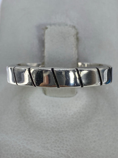 Anillo de plata 925 con eslabones geométricos pulidos en la mano de un hombre