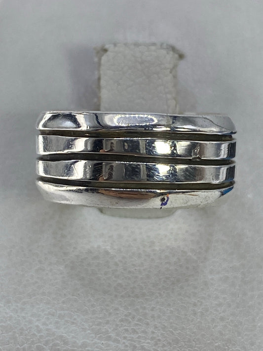 Anillo de plata triple banda pulida en la mano, vista frontal