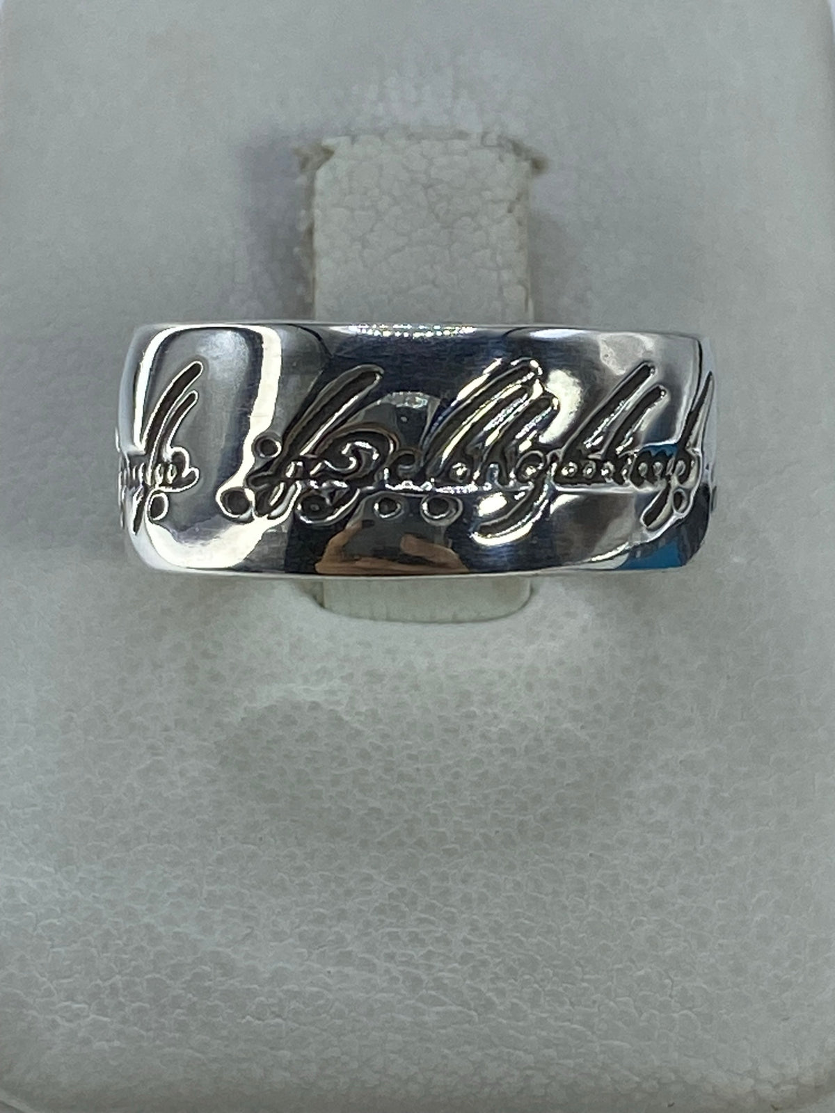 Anillo de plata 925 con banda grabada, vista frontal sobre fondo gris