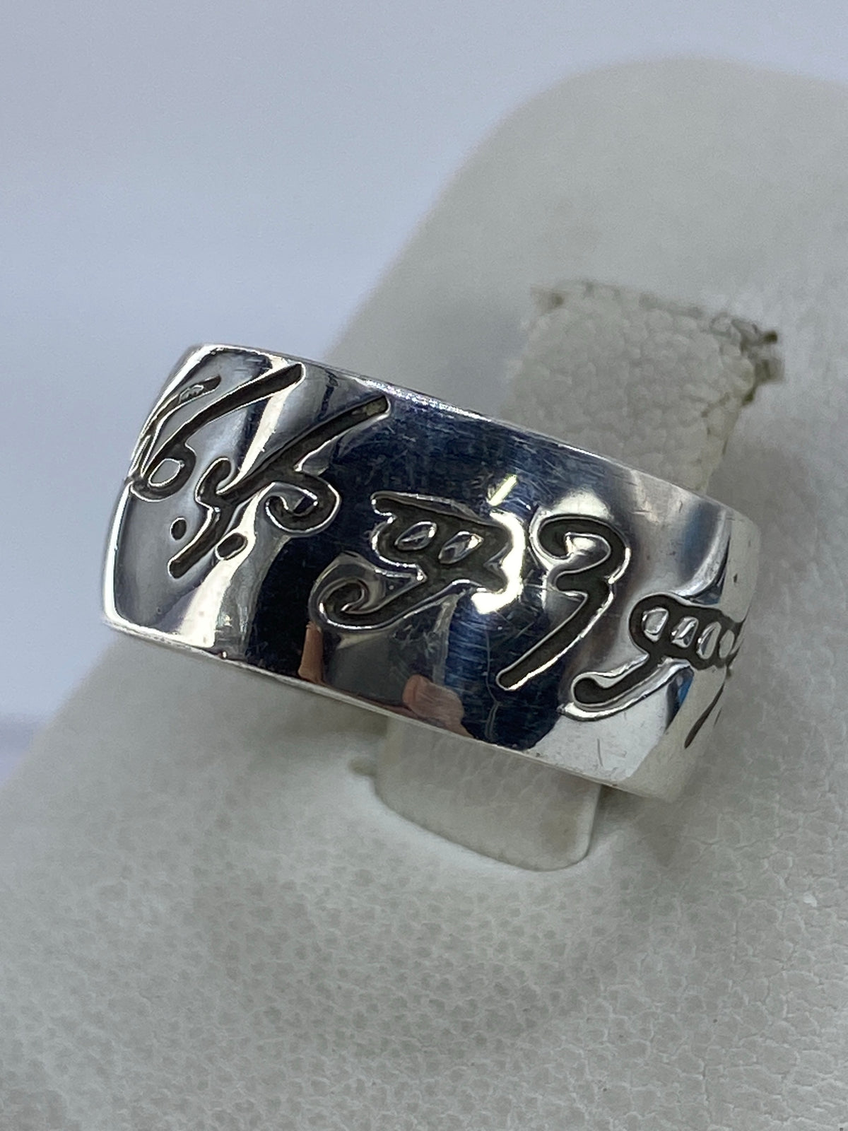 Anillo de plata grabado colocado en dedo, demostración de talla y comodidad