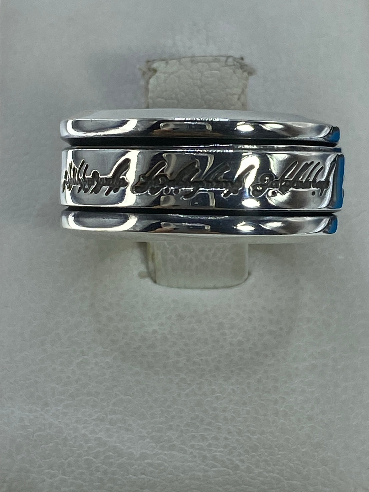 Anillo de plata 925 pulido en banda lisa sobre mostrador blanco, vista frontal