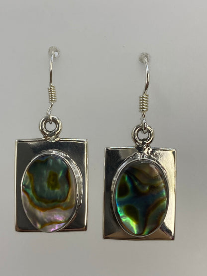 Par de aretes de plata con concha de abulón iridiscente, reflejos azul y verde en fondo gris