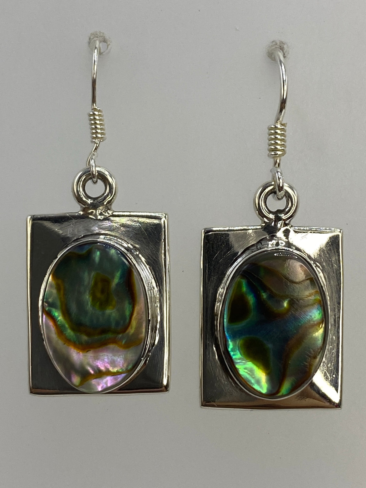Medida de los aretes en regla: 3.6 cm de largo, 1.4 cm de ancho