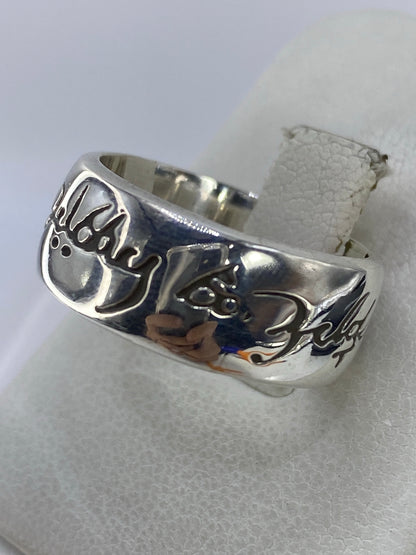 Banda de plata grabada en detalle, mostrando el trazo de caligrafía artesanal