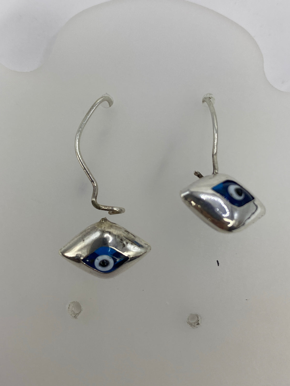 Par de aretes ojo turco azul de plata 925 sobre fondo blanco