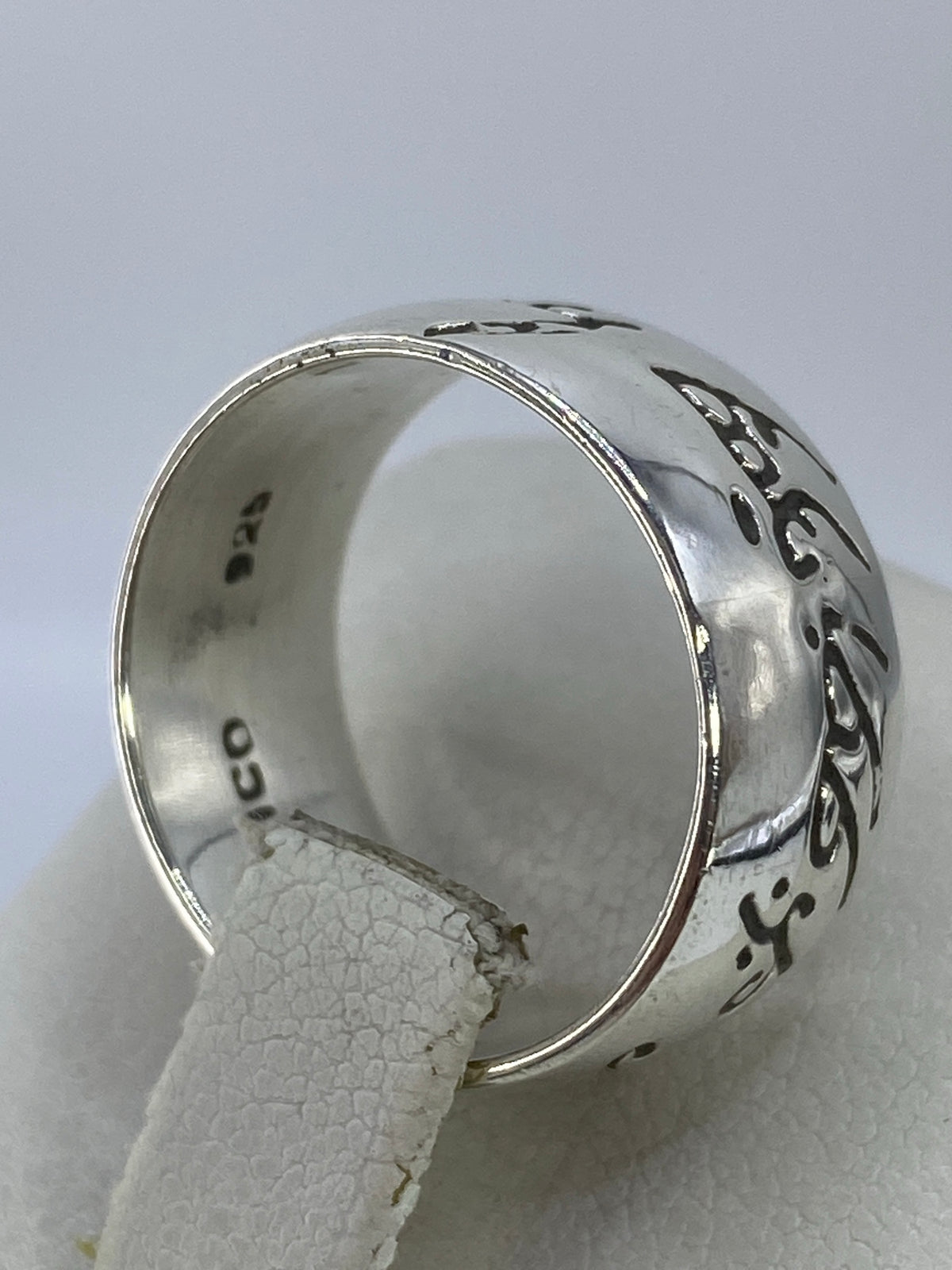 Anillo de plata grabado puesto en dedo medio mostrando comodidad y ajuste
