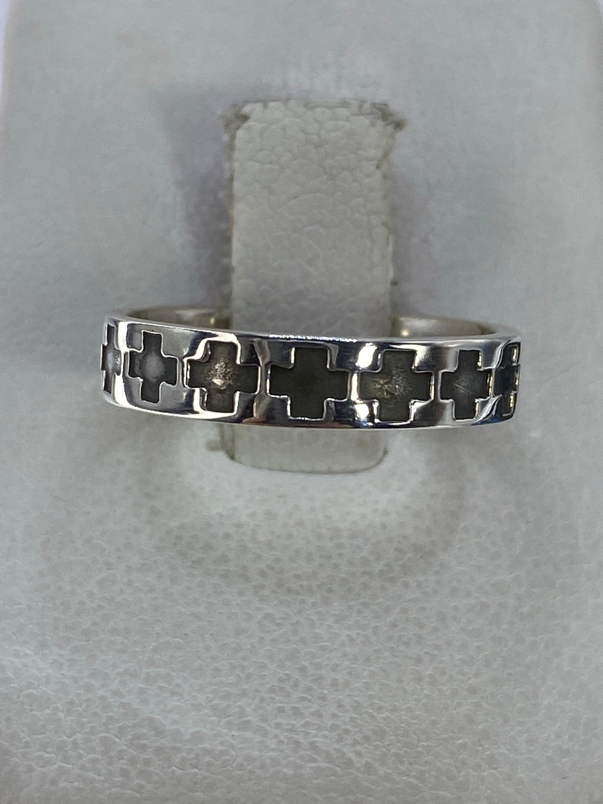 Anillo de plata con cruces geométricas entrelazadas en vista frontal