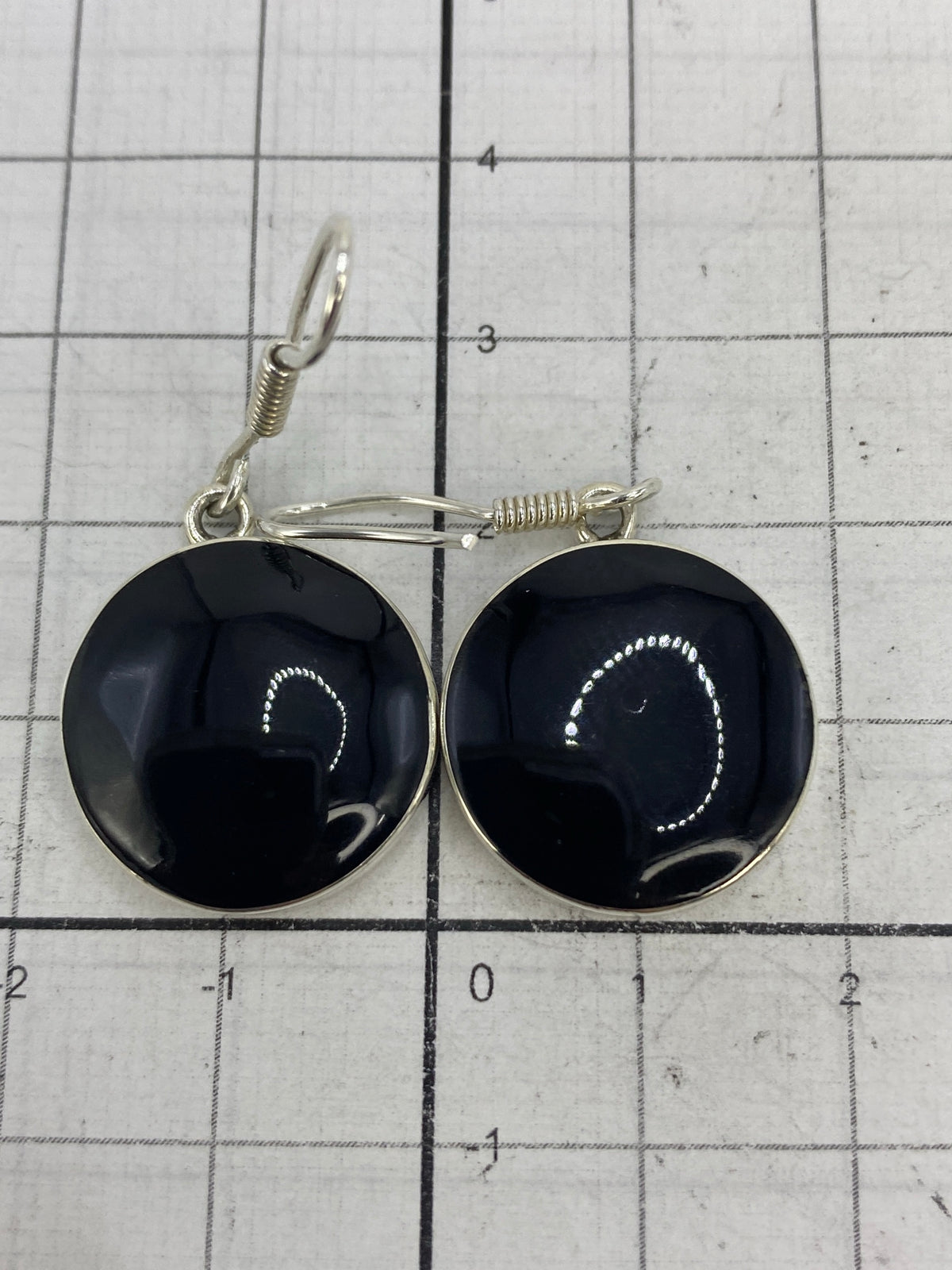 Aretes sobre fondo blanco mostrando el Quinto 950 en la base