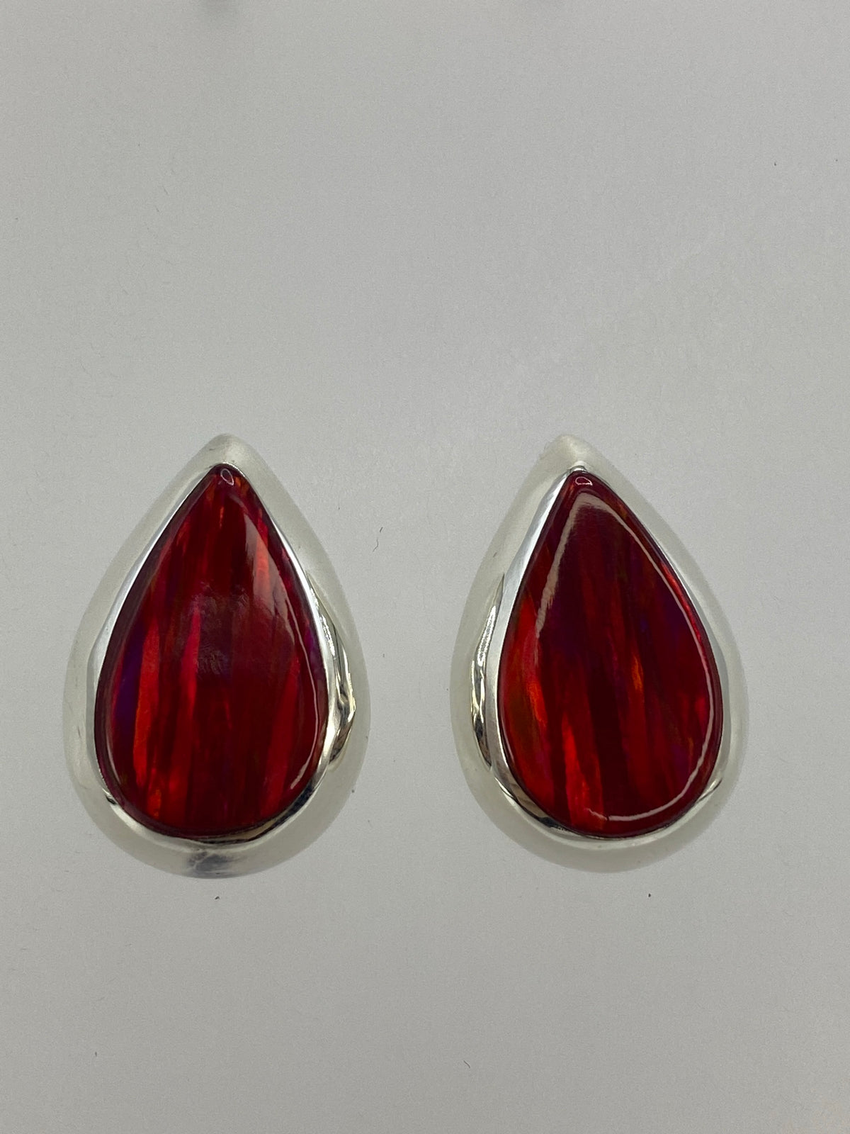 Par de aretes de plata 925 con ópalo de fuego rojo engastado, sobre fondo blanco