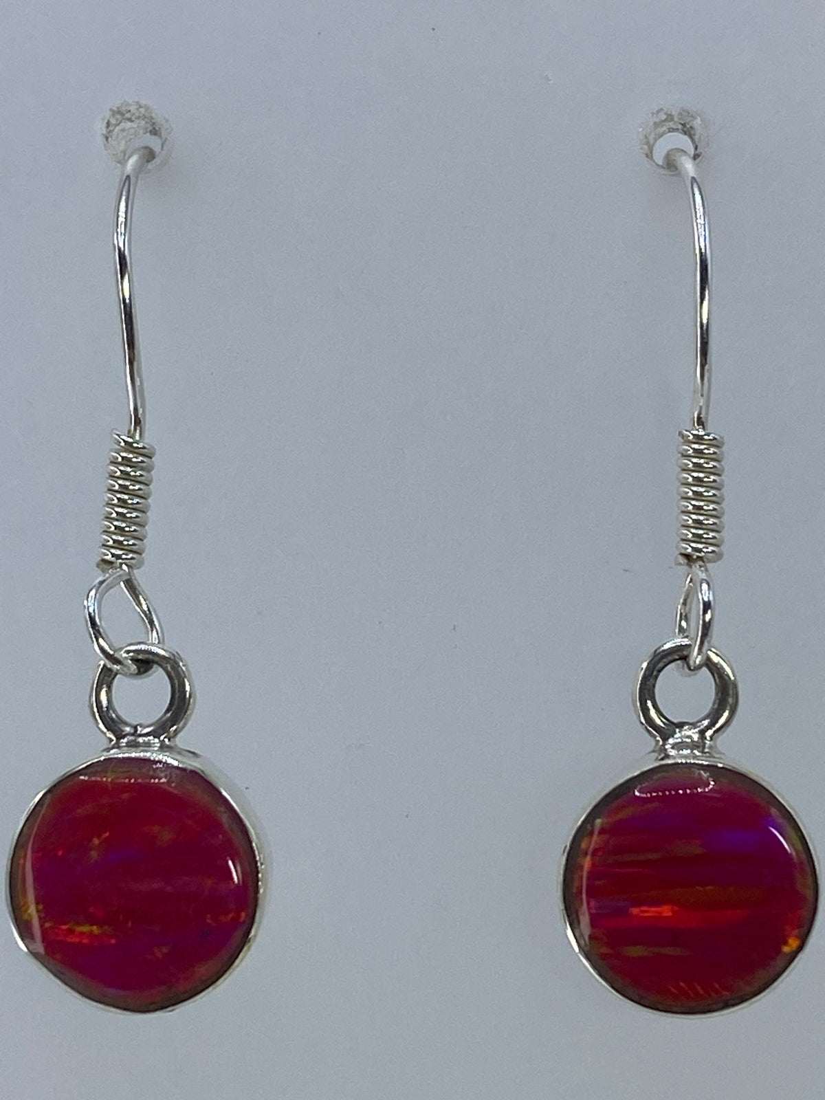 Aretes de ópalo rosa sobre fondo blanco mostrando la profundidad del color