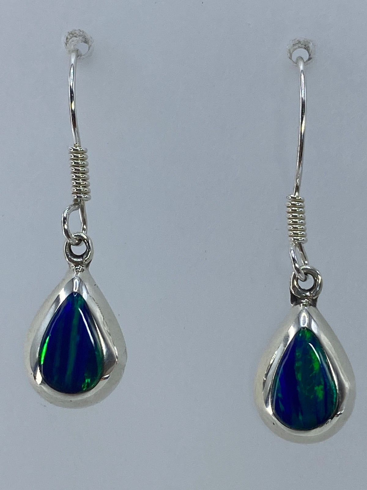 Aretes de plata 925 con ópalo de fuego verde engastado, largos de 3 cm, sobre fondo blanco