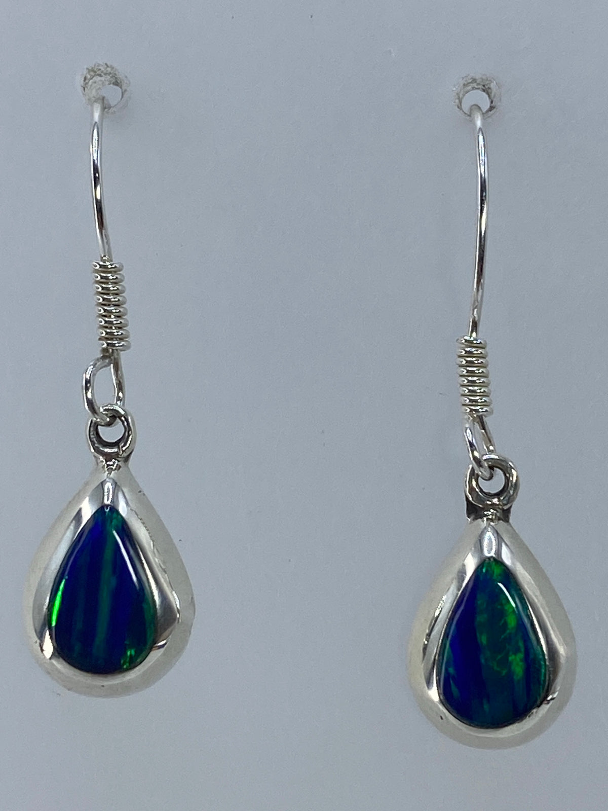 Par de aretes con ópalo verde mostrando el Quinto 925 en el reverso