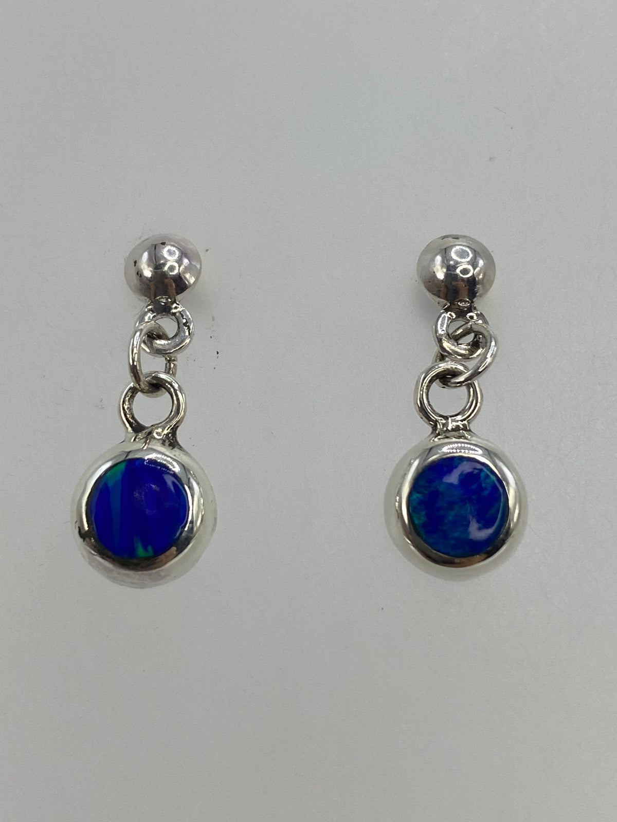 Detalle del engaste de piedra a mano en arete de ópalo azul