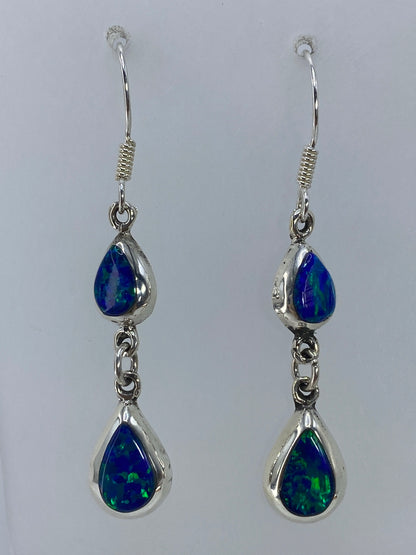Par de aretes de plata con ópalo de fuego verde olivo engastado, sobre fondo gris