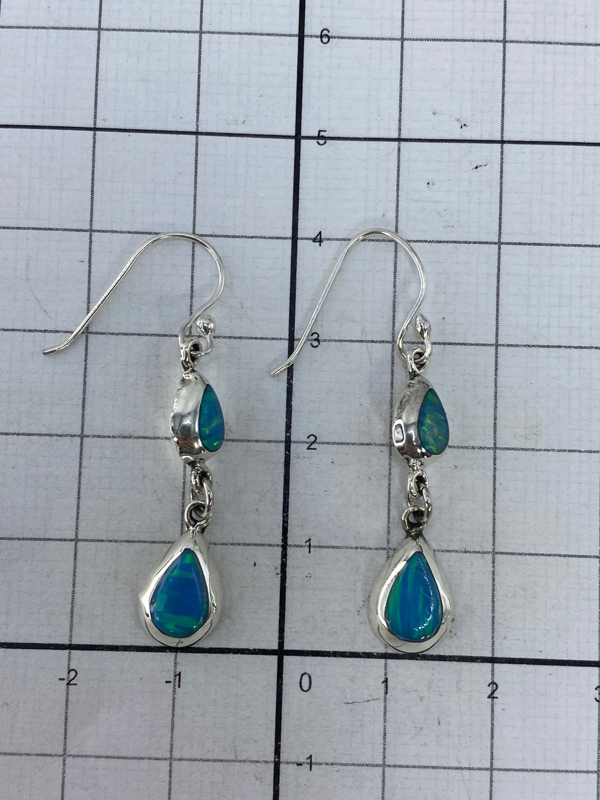 Aretes sobre fondo blanco con marca de Quinto 925 visible en la base