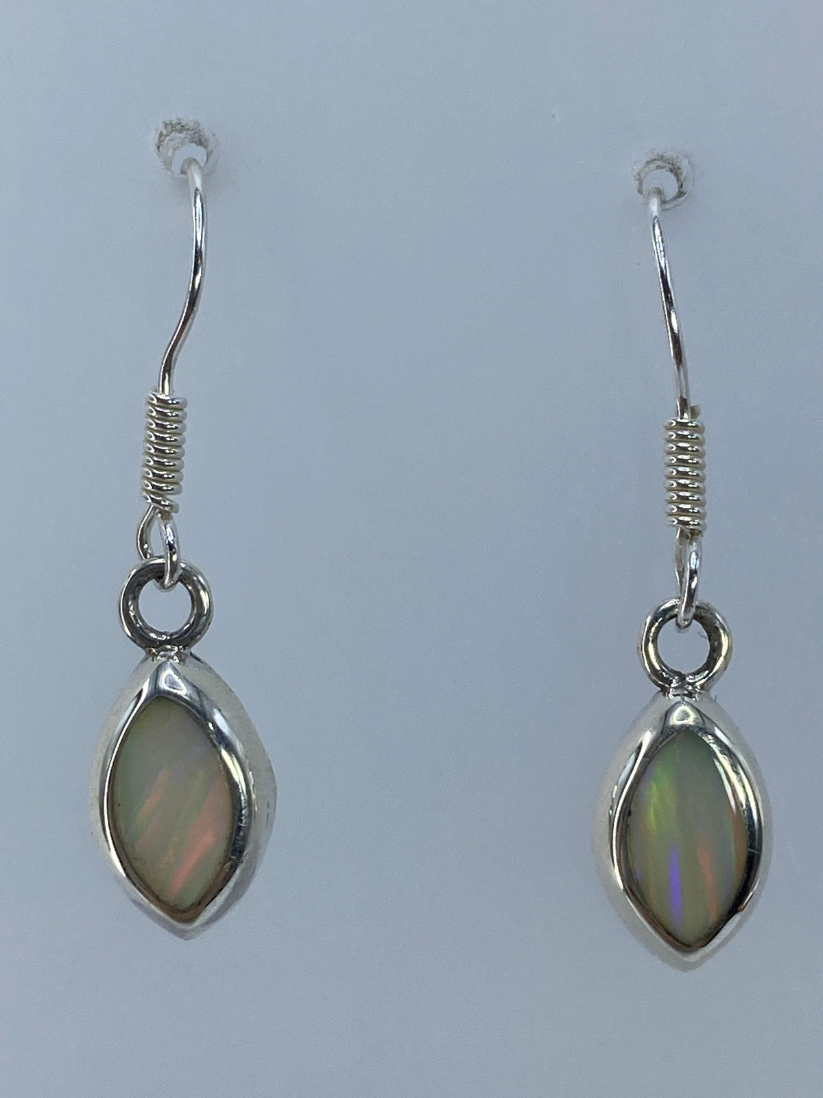 Par de aretes de plata 950 con ópalo de fuego multicolor, engastados a mano, mostrando destellos de verde y azul