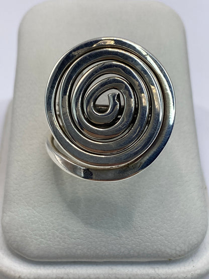 Anillo de plata calado con espiral concéntrica en la mano de una mujer