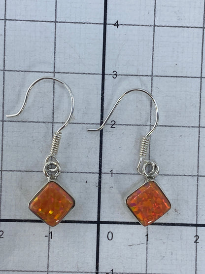 Medición de los aretes mostrando 2.9 cm de largo en escala