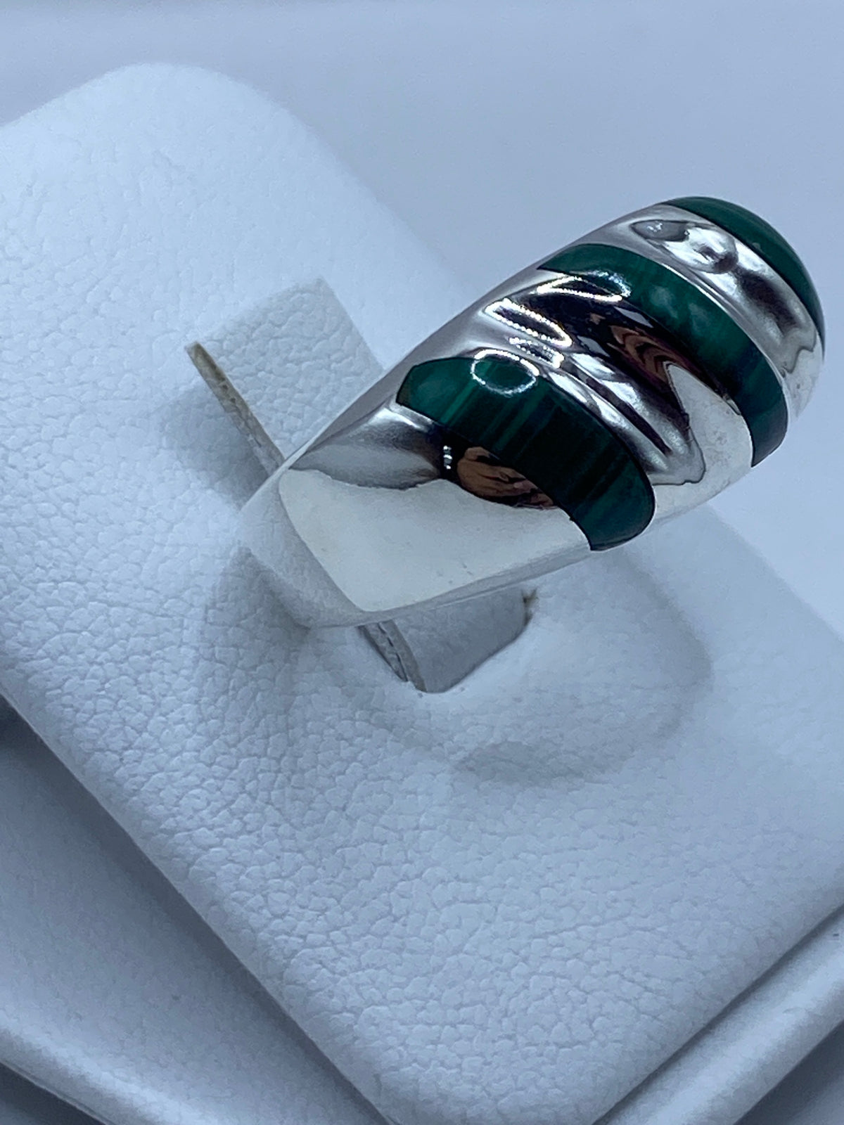 Vista frontal del anillo con malaquita verde y vetas negras características de la piedra