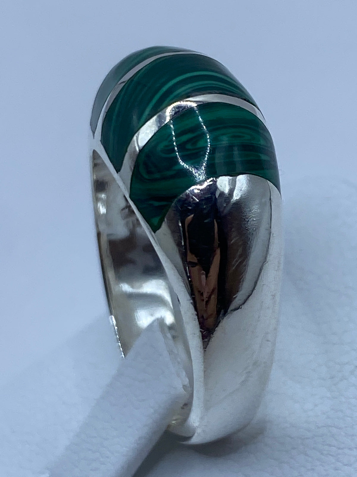 Anillo malaquita en la mano mostrando el tono verde profundo y el contraste con la plata