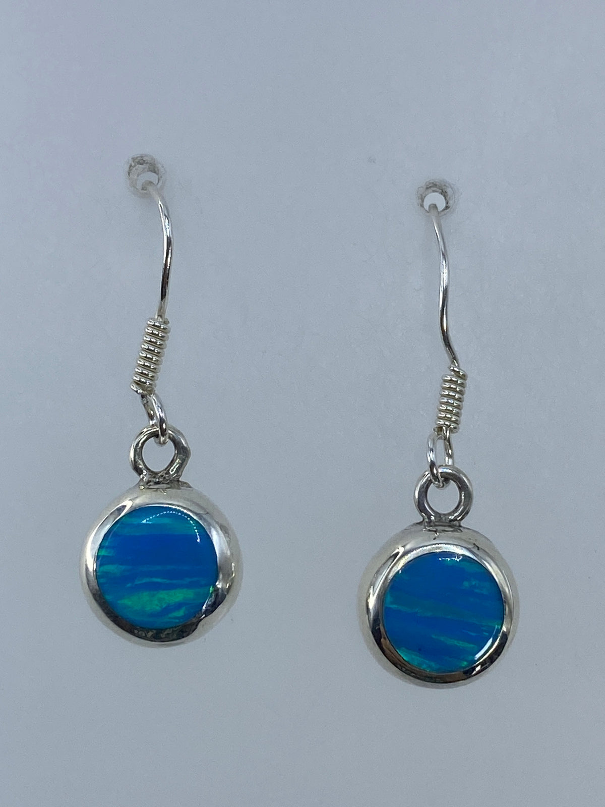 Par de aretes de plata 950 con ópalo de fuego verde olivo sobre fondo blanco