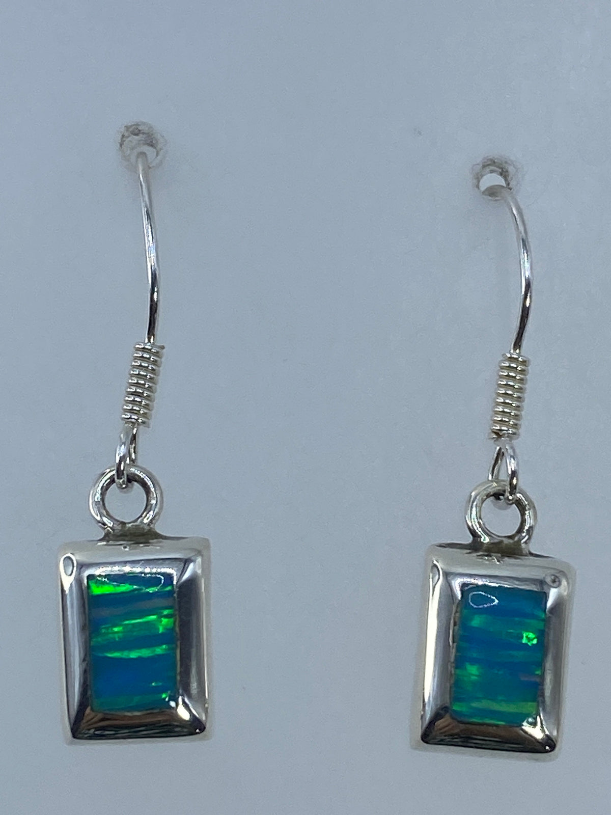 Aretes sobre regla mostrando 3 cm de largo — visión frontal